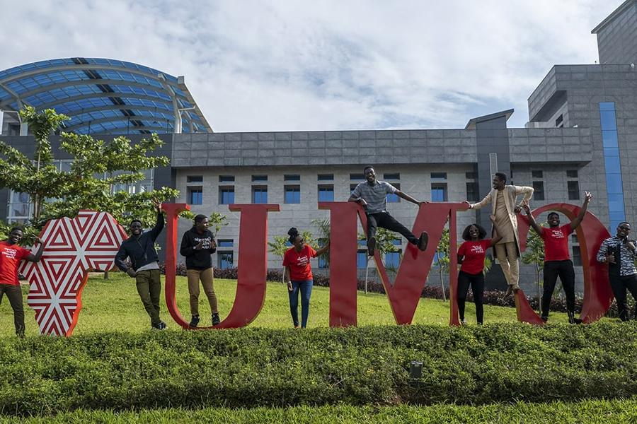 Students at CMU-Africa campus by large CMU letters